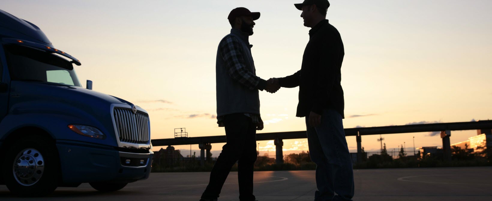 Two truck drivers shaking hands
