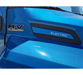 Closeup image of blue Exterior of a yellow Interntional Trucks MV Series Electric vehicle