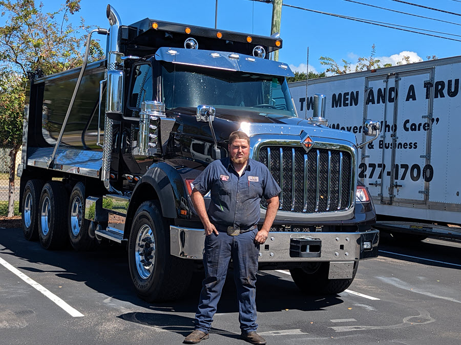 Technician_Dustin_Taylor_stands_in_front_of_truck