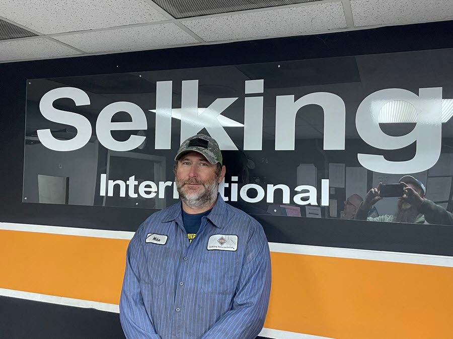 Technician_Mike_Dunfee_stands_in_front_of_Selking_International_sign